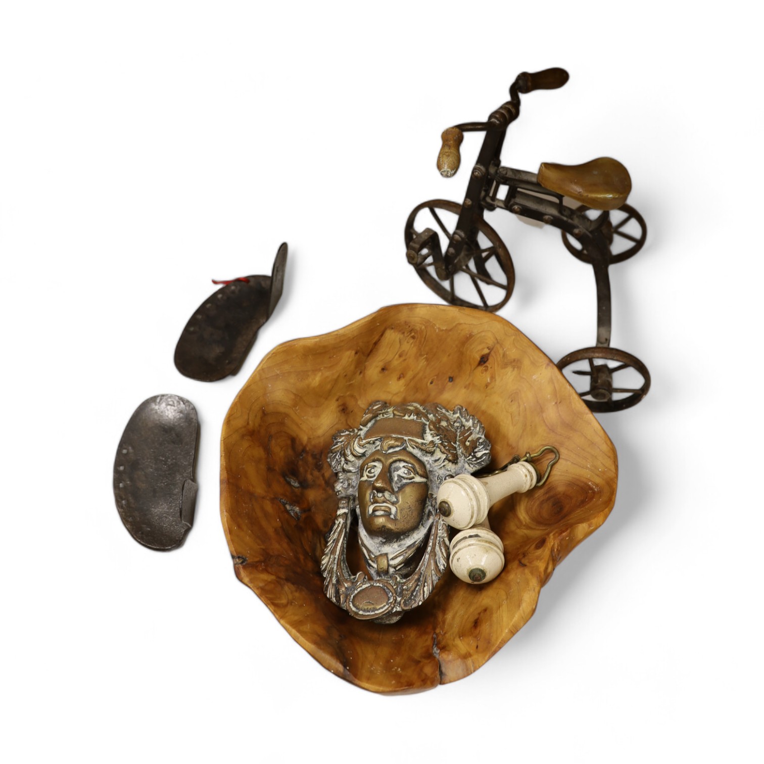 A cast iron toy model of a tricycle, a carved wooden bow, a classical figurative door knocker, a pair of metal cow shoes and two ceramic cistern pulls, bowl 30cm diameter. Condition - fair